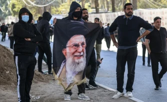 Des manifestants irakiens, dont l’un tient un portrait du guide suprême iranien assassiné, Ali Khamenei, se tiennent près de la Zone verte, où se trouve l’ambassade des États-Unis, à Bagdad, le 1er mars 2026.