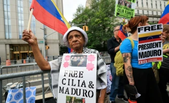 Des manifestants brandissent des pancartes en soutien à Nicolas Maduro et à son épouse Cilia Flores, à l'extérieur d'un tribunal de New York où le président vénézuélien déchu doit comparaître, le 22 juillet 2026 