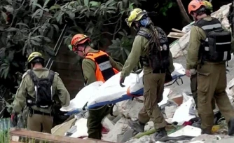 Image tirée d'une vidéo d'AFPTV montrant des équipes de secours sortant les corps de victimes des décombres d'un immeuble résidentiel détruit par une attaque de missile iranienne dans la ville de Haïfa, dans le nord d'Israël, le 6 avril 2026