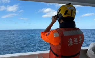 Cette photo fournie le 29 décembre 2025 par les garde-cÎtes taïwanais montre un agent observant un navire chinois, naviguant à 23 milles marins au nord-ouest de l'ßlot Pengjia, au nord de Taïwan