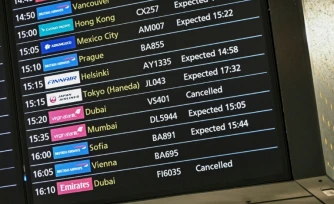 Un écran affiche des vols annulés en provenance de Dubai, le 1er mars 2026 à l'aéroport international Heathrow de Londres