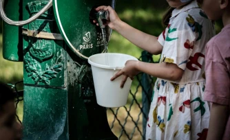 Une enfant remplit un seau d'eau à Paris, lors d'une vague de chaleur qui touche plusieurs pays européens, le 25 mai 2026
