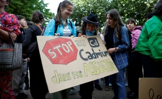 Des manifestants brandissent une pancarte sur laquelle on peut lire "Stop au cadmium dans nos assiettes" lors d'une manifestation aux côtés de députés, sur l'esplanade des Invalides à Paris, le 2 juin 2026