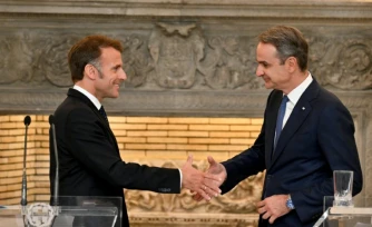 Le président français Emmanuel Macron (G) serre la main du Premier ministre grec Kyriakos Mitsotakis à l'issue d'une conférence de presse, le 25 avril 2026 à Athènes 