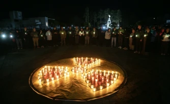 Des personnes allument des bougies reproduisant la signalétique avertissant d'un danger radioactif à l'occasion du 40e anniversaire de l'accident de Tchernobyl, à Slavoutytch, dans le nord de l'Ukraine, le 26 avril 2026