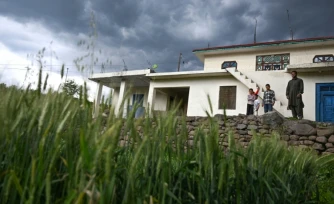 Mohammad Rashid (d) devant sa maison, surmontée d'un bunker récemment construit, dans le village de Kasaliyan, près de la frontière avec le Pakistan, le 6 avril 2026 en Inde