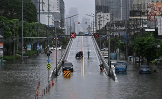 Des automobilistes font demi-tour depuis un pont surplombant des eaux de crue le long de la route Phetchaburi à Bangkok, le 26 septembre 2026