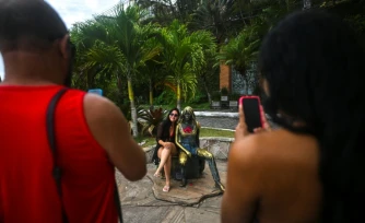 Une touriste pose à côté de la statue de Brigitte Bardot, à Buzios, au Brésil, le 3 janvier 2026
