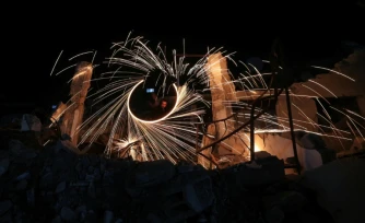 Des Palestiniens déplacés allument des feux d'artifice pour célébrer le début du mois du ramadan, dans un camp du centre de la bande de Gaza, le 17 février 2026