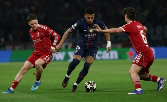 Florian Wirtz (G) de Liverpool voit filer Désiré Doué (C) du Paris SG lors de la victoire 2 à 0 des Parisiens, en quart de finale aller de Ligue des champions, le 8 avril 2026 au Parc des Princes