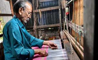 Un artisan travaille sur un métier à tisser traditionnel dans un atelier de Tangail, le 2 mars 2026 au Bangladesh