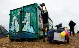 Un participant nettoie le site militaire où s'est déroulée une rave party "teknival" à Cornusse, près de Bourges, le 4 mai 2026 dans le Cher