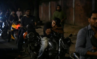 Un homme fait la sieste sur sa moto dans une file d'attente pour du carburant à Dacca, capitale du Bangladesh, le 21 avril 2026