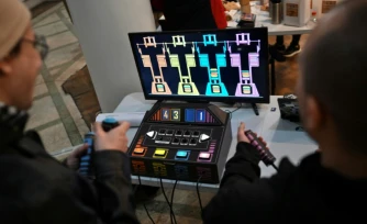 Des personnes jouent à un jeu vidéo fabriqué à partir de composants électroniques recyclés lors de la 3e Rencontre fédérale Cyberciruja à Buenos Aires, le 16 août 2025 en Argentine