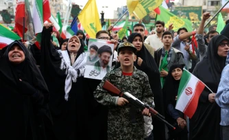 Un jeune Iranien en uniforme militaire brandit un fusil factice lors d'un rassemblement des partisans du pouvoir, le 29 avril 2029 à Téhéran