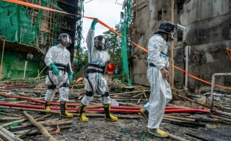 Sur cette photo diffusée par la police hongkongaise le 1er décembre 2025, des agents chargés d'identifier les victimes de l'incendie travaillent sur les lieux de l'incendie du complexe de Wang Fuk Court à Tai Po (Hong Kong)