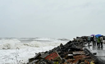 Des passants le long de la cĂŽte du golfe du Bengale, Ă Kakinada, en Inde, le 27 octobre 2026, avant le passage attendu du cyclone Arnab