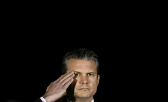 Le secrétaire américain à la Défense Pete Hegseth salue tandis que des membres d’une équipe de l’armée américaine transportent un cercueil de transfert recouvert d’un drapeau contenant la dépouille du sergent Benjamin N. Pennington, 26 ans, originaire de Glendale, lors d’une cérémonie solennelle de rapatriement à la Dover Air Force Base, à Dover, le 9 mars 2026