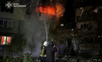Photo publiée par le service d'urgence ukrainien, le 22 octobre 2025, de sauveteurs ukrainiens luttant contre un incendie dans un immeuble résidentiel après une frappe aérienne russe à Zaporijjia