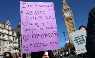 Des militants en faveur d'une modification de la loi sur l'aide médicale à mourir, rassemblés devant le palais de Westminster,le 24 avril 2026 à Londres