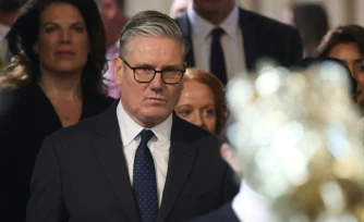Le Premier ministre britannique Keir Starmer (c) retourne à la Chambre des communes aprÚs avoir écouté le discours du roi lors de l'ouverture solennelle du Parlement au palais de Westminster, le 13 mai 2026 à Londres