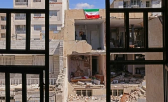 Un drapeau iranien sur un immeuble détruit  à Vahdat, au sud-ouest de Téhéran le 3 avril 2026