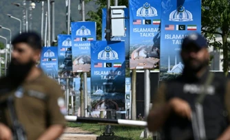 Des membres des forces de sécurité montent la garde le long d'une route temporairement fermée en prévision des pourparlers de paix américano-iranien, le 20 avril 2026 à Islamabad, au Pakistan 