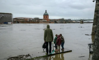 Des personnes observent la Garonne après de fortes pluies, à Toulouse, le 11 février 2026