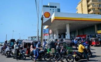 Des motoyclistes font la queue pour prendre du carburant à une station-service de Wellawatte, près de Colombo, le 16 mars 2026 au Sri Lanka 