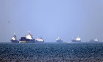 Photo fournie par l'agence iranienne Isna le 4 mai 2026, montrant des bateaux coinvés dans le détroit d'Ormuz au large de Bandar Abbas, dans le sud de l'Iran