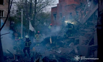 Photo prise et diffusée par le Service d'État des situations d'urgence de l'Ukraine, le 25 avril 2026, montrant des secouristes dans les décombres d'un immeuble résidentiel après une attaque russe à Dnipro, dans le centre-est du pays 