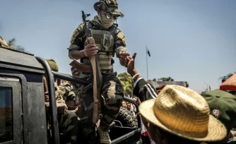 Un militaire malgache salue du poing un civil alors que des manifestants se rassemblent pour un meeting de la société civile devant l'hôtel de ville d'Antananarivo, le 13 octobre 2025