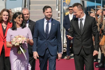 Le vice-président américain JD Vance (c) et sa femme, Usha Vance, accueillis par le ministre hongrois des Affaires étrangères, Peter Szijjarto, le 7 avril 2026 à Budapest, en Hongrie