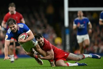Le capitaine français Antoine Dupont plaqué par le Gallois Tomas Williams pendant le match du Tournoi des six nations samedi à Cardiff, au Pays de Galles.