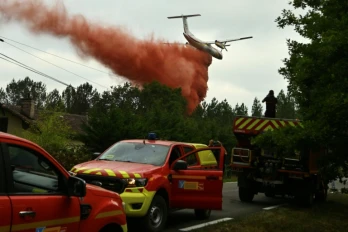 Un avion de la sécurité civile DASH verse du liquide retardateur sur la forêt en feu, Luglon, le 15 août 2026