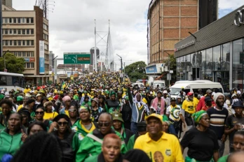 Des milliers de manifestants, appelés à défiler par l'ANC, traversent l'emblématique pont Nelson Mandela de Johannesburg le 21 mars 2026.