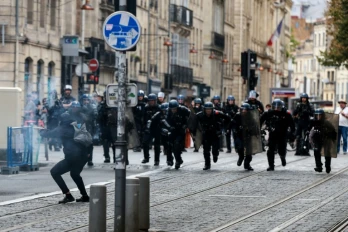 Des gendarmes mobiles chargent un manifestant pointant un mortier d'artifices vers eux pendant une manifestation lycéenne à Bordeaux, le 1er octobre 2026