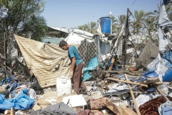 Un jeune Palestinien déplacé examine les dégâts sur le site d'une frappe israélienne présumée contre une tente à Khan Younès, dans le sud de la bande de Gaza, le 16 août 2026