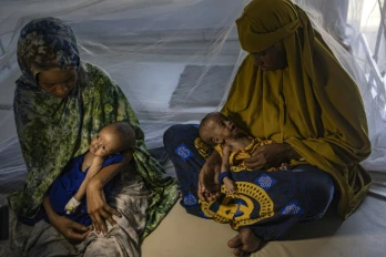 Des femmes somaliennes récemment déplacées tiennent dans leurs bras leurs bébés souffrant de malnutrition sévère dans un centre de santé, à Kismayo, le 22 avril 2026 