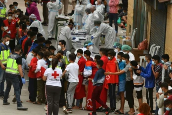Des jeunes migrants font la queue pour un test ant-Covid à leur arrivée à Ceuta, le 19 mai 2021 en Espagne