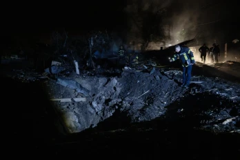 Un pompier ukrainien examine un cratère après une frappe de missile russe qui a touché des habitations à Kiev dans la soirée du 21 octobre 2026