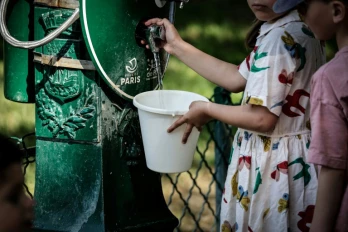 Une enfant remplit un seau d'eau à Paris, lors d'une vague de chaleur qui touche plusieurs pays européens, le 25 mai 2026