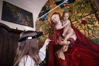 Une experte travaille à la restauration de "La Vierge au buisson de roses" peinte en 1473 par Martin Schongauer, le 5 mars 2026 dans l'église des Dominicains à Colmar, dans le Haut-Rhin