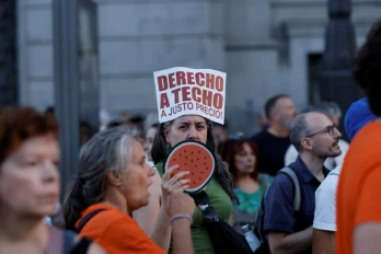 Un manifestant tient une pancarte portant l'inscription « Droit à un toit à un prix équitable » lors d'une manifestation contre les expulsions et la crise du logement sur la Puerta del Sol à Madrid, le 26 septembre 2026