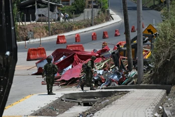 Des soldats se tiennent près des restes d'un péage en construction détruit par une explosion à Santander de Quilichao, en Colombie, le 8 août 2026