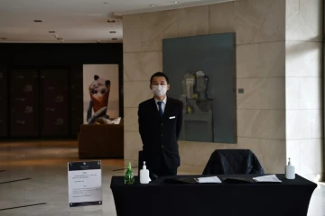 Dans un hôtel de Wuhan, un employé chargé de prendre la température de quiconque entre dans le bâtiment, le 29 janvier 2020