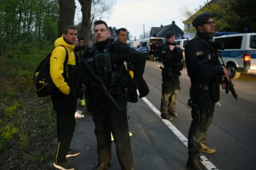 Le défenseur du Borussia Lars Bender (g) et ses coéquipiers protégés par la police après les explosions ayant visé leur bus, le 8 avril 2017