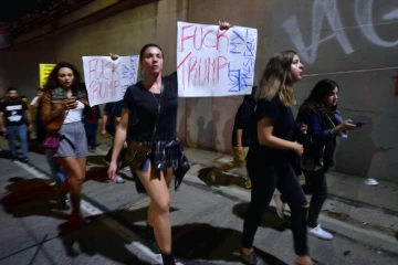 Des manifestants brandissent des banderoles hostiles au président élu Trump, et défilent sur une autoroute dans le centre de Los Angeles, le 10 novembre 2016 dans la nuit