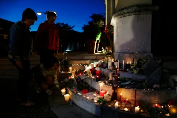 Des gens allument des bougies à Saint-Etienne du Rouvray le 26 juillet 2016
