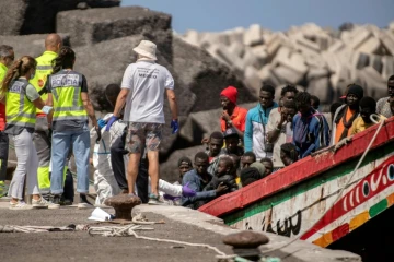 Des membres des forces de police et des services d'urgence aident des migrants à leur arrivée au port de Restinga sur l'île d'El Hierro, le 18 août 2024 aux Canaries